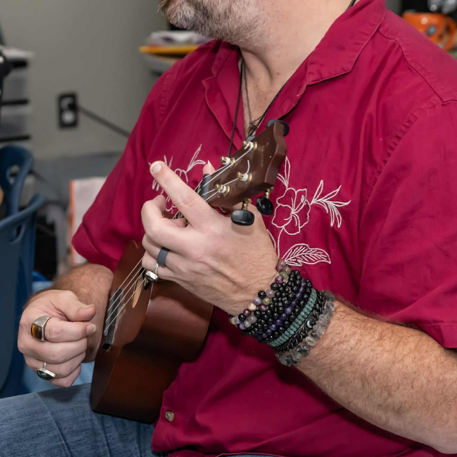 Close-up of John Ford’s hands fretting a chord on a ukulele