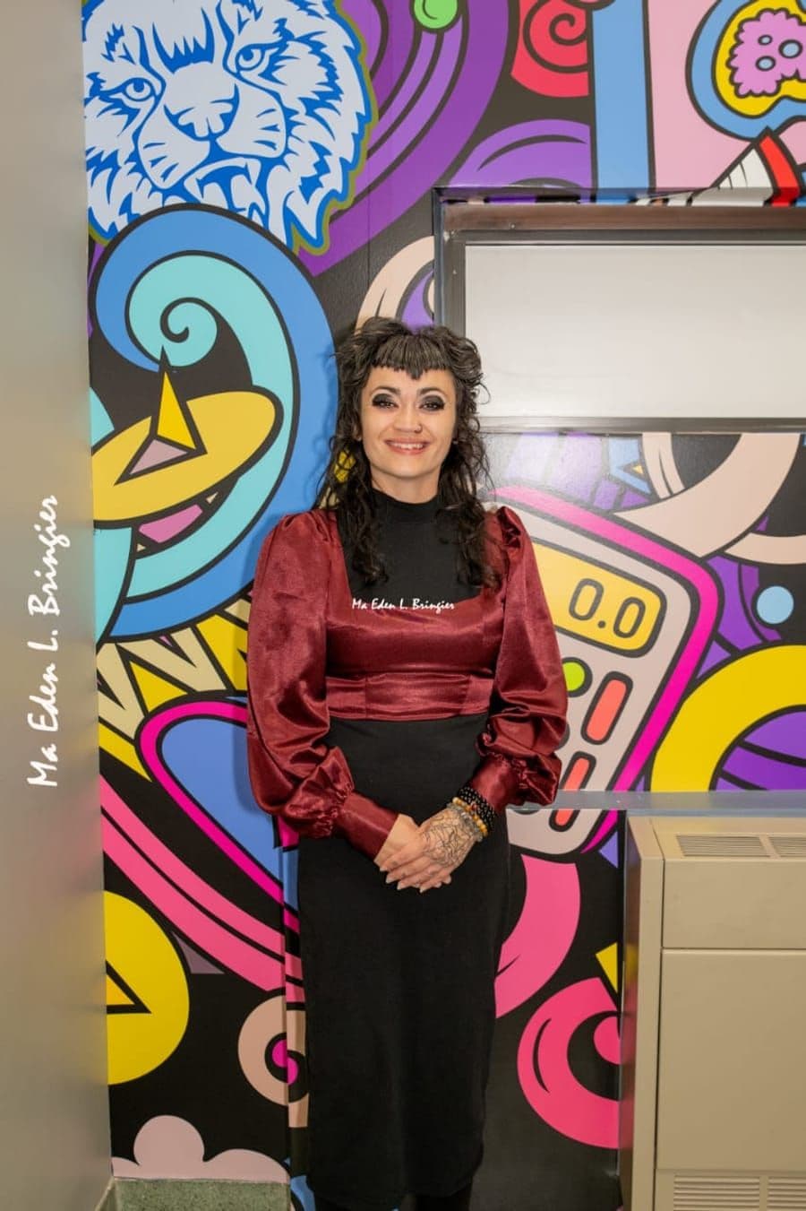 Jessica Ford, co-founder of Sol Vibrations, standing in front of a colorful mural