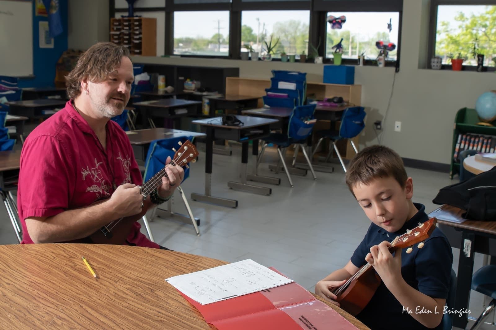 John Ford and a young student play ukulele together at a classroom table